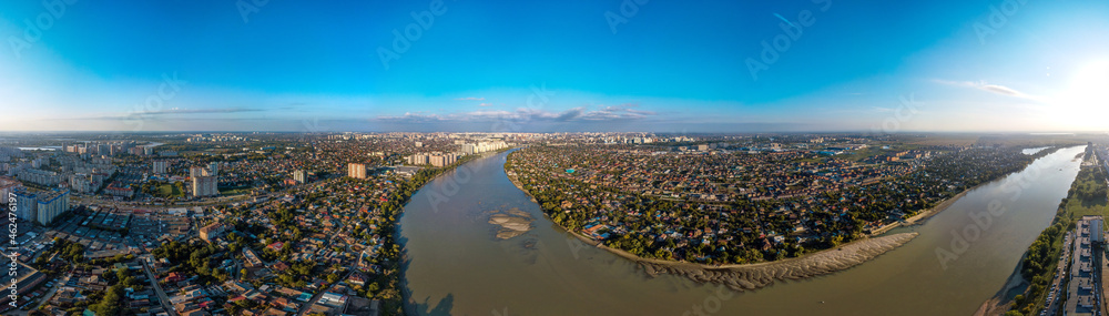 A large aerial panorama of the shallow Kuban River near the Yubileiny microdistrict of the city of Krasnodar and the village of Novaya Adygea (South of Russia) on a sunny day in mid-autumn.