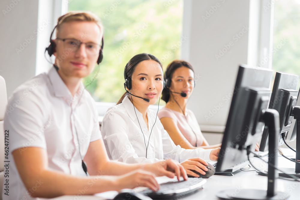 Diverse team of young professionals is working in the phone support office. Working day of sales managers in the call center. Business, telephone consulting and problem solving. Diverse team of young professionals is working in the phone support office. Working day of sales managers in the call center. Business, telephone consulting and problem solving.