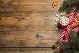 Flat lay composition of delicious hot chocolate with marshmallows and Christmas decor on wooden table, space for text