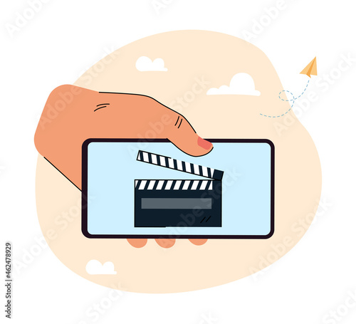 Human hand holding huge smartphone with clapper on screen. Filmmaking application flat vector illustration. Creating or editing video content concept for banner, website design or landing web page