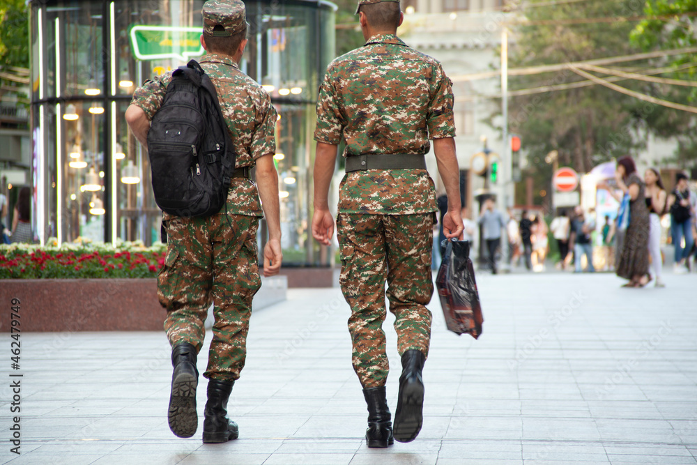 two soldiers walking in street two soldiers walking in street