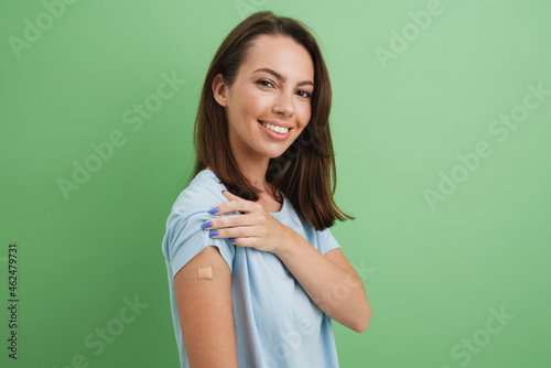 Fototapete Young brunette woman laughing while showing her bandage