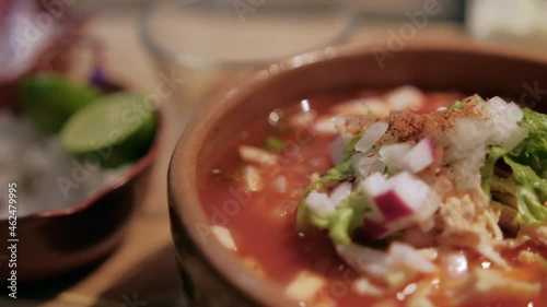 Clay bowl of delicious and traditional Mexican pozole photo