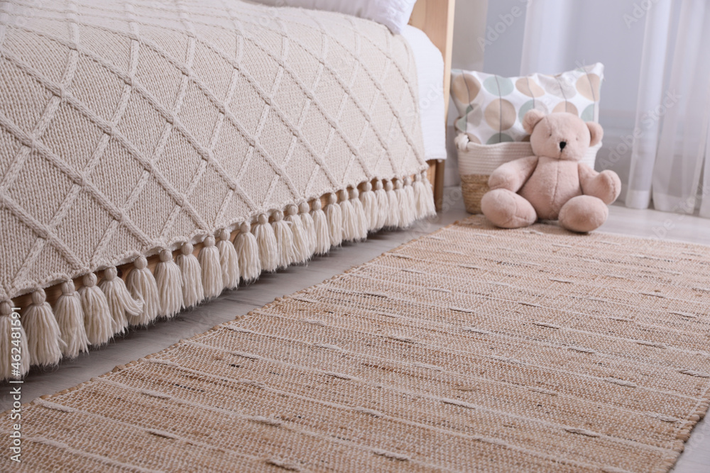 Stylish children's room interior with beige rug and bed - obrazy, fototapety, plakaty 