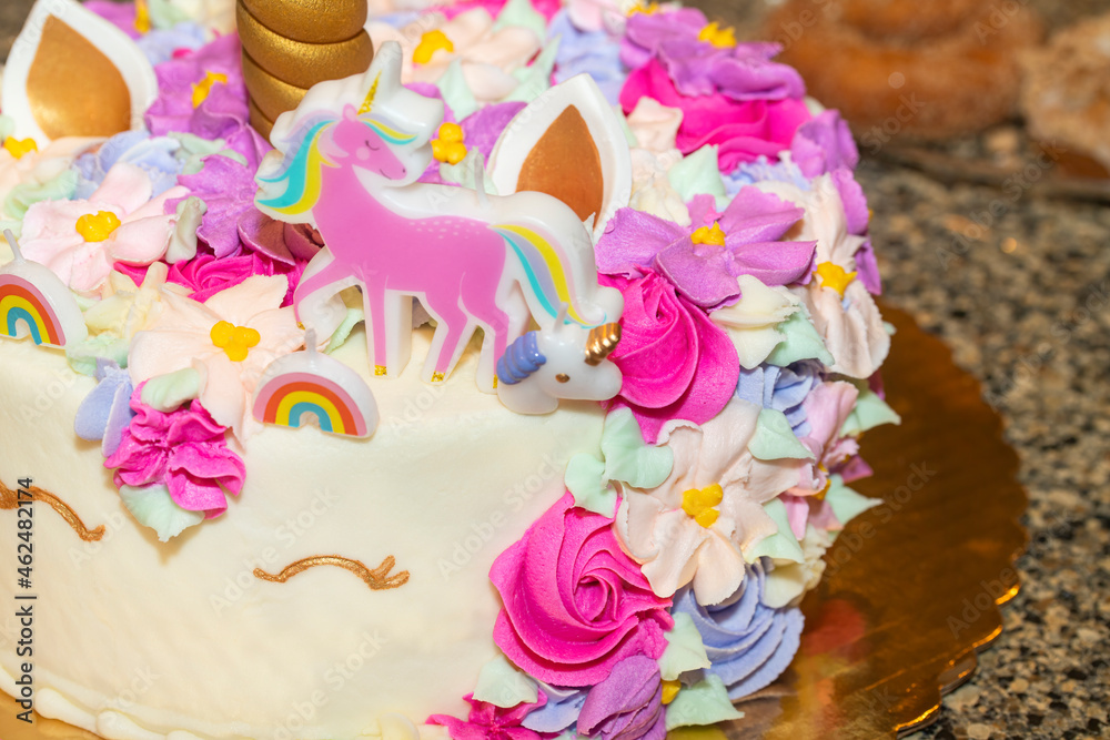 Unicorn birthday cake with flowers and rainbows
