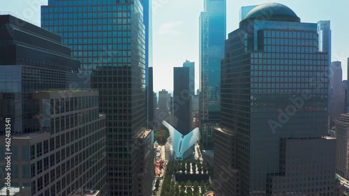 Drone flying close between modern architecture glass buildings business offices in New York downtown. Aerial above narrow urban street towards ground zero 911 memorial park and museum in Manhattan