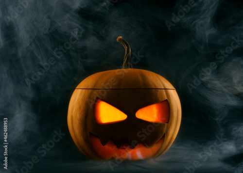 Spooky carved pumpkin for Halloween celebration with smoke and fog