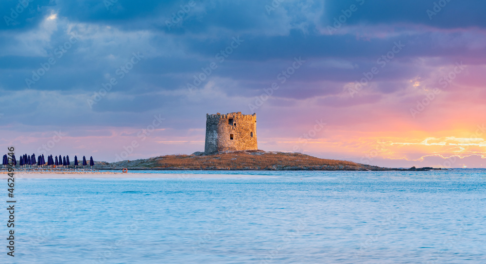 Stunning sunrise over the Aragonese Tower and La Pelosa Beach bathed by a calm turquoise water. Spiaggia La Pelosa, Stintino, north-west Sardinia, Italy.