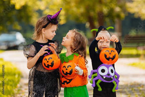 Happy Halloween. three running kids with a basket for sweets