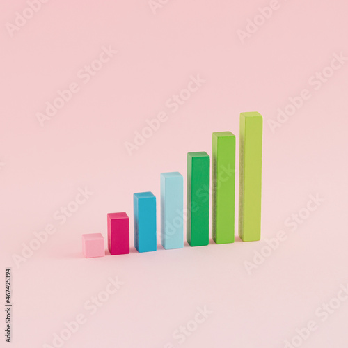 A creative arrangement of statistical data representation made of wooden cuboids on a pink background. Minimal data or development concept. Statistics  analysis and diagram Inspiration.