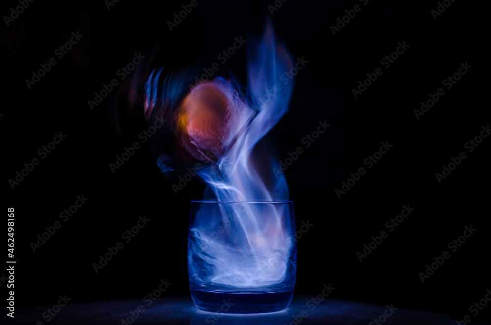 burning sambuca glasses on a black background with a purple flame