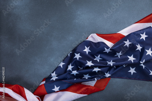 Close up of ruffled American flag on dark background. Satin texture curved flag of USA. Memorial Day or 4th of July. Banner, freedom concept