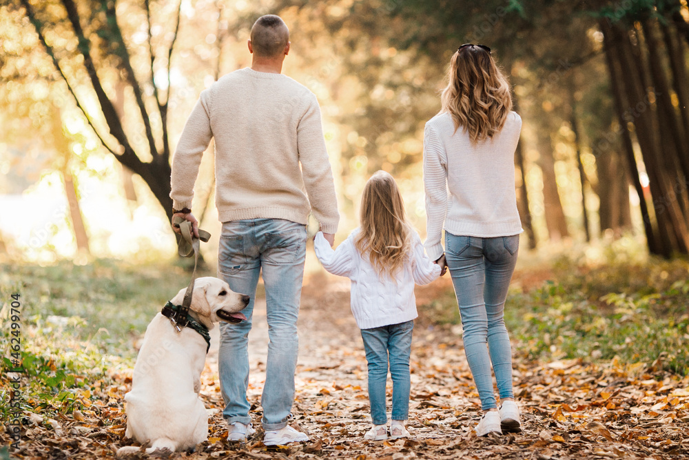 Happy beautiful family with dog labrador is having fun together walking the in park. Happy beautiful family with dog labrador is having fun together walking the in park.