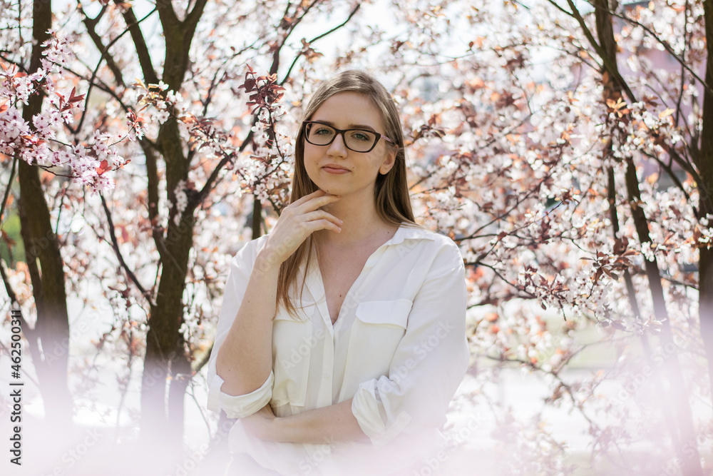 a girl surrounded by blossoming trees in the park a girl surrounded by blossoming trees in the park