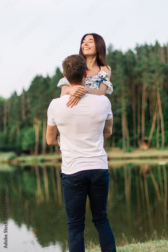 Young loving couple hugging and walking near lake. Young loving couple hugging and walking near lake.