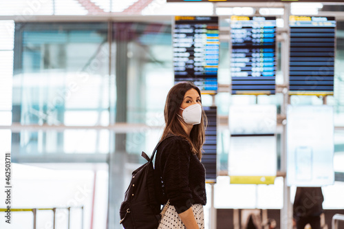 Tourist woman at the airport waiting for her flight. Wearing a mask for covid 19 protection. Lifestyle. Travel