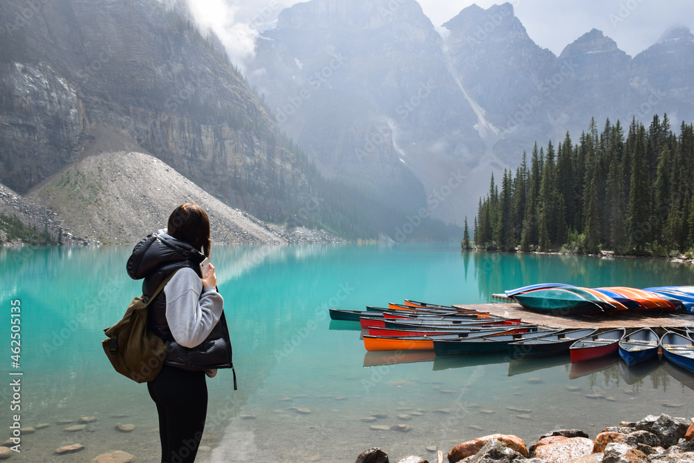 Young girl looking at view of lake, canoes and mountains