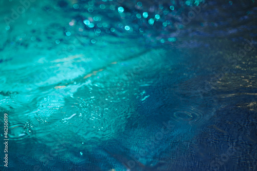 Water blue background with waves and lighting. Neon water texture © Anastasia Studio