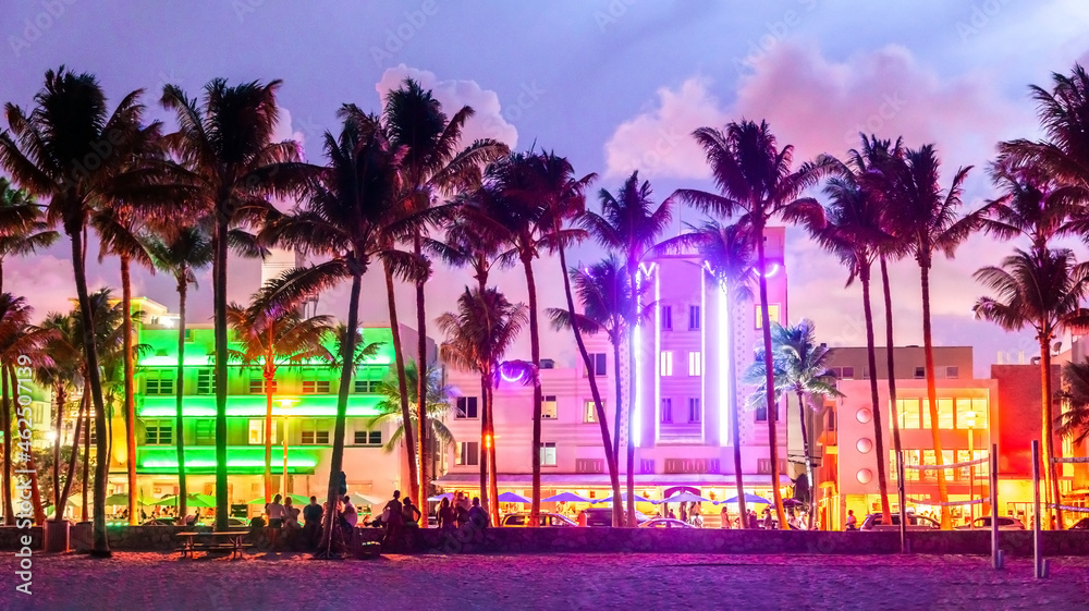 Fototapeta premium Miami Beach Ocean Drive hotels and restaurants at sunset. City skyline with palm trees at night. Art deco nightlife on South beach