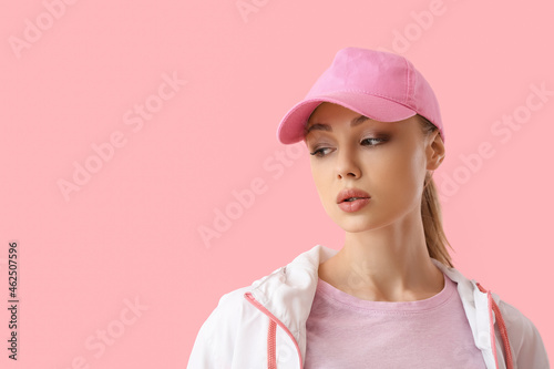 Canvas Print Pensive woman in baseball cap on pink background