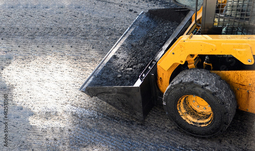 Front end loader carrying asphalt during paving