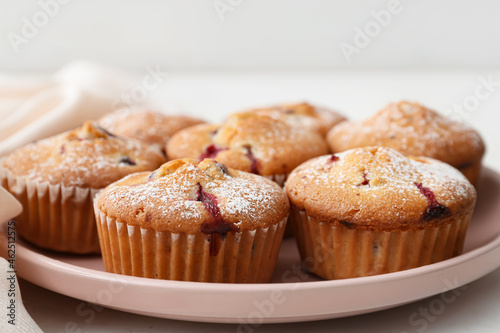 Plate with delicious cranberry muffins on table, closeup
