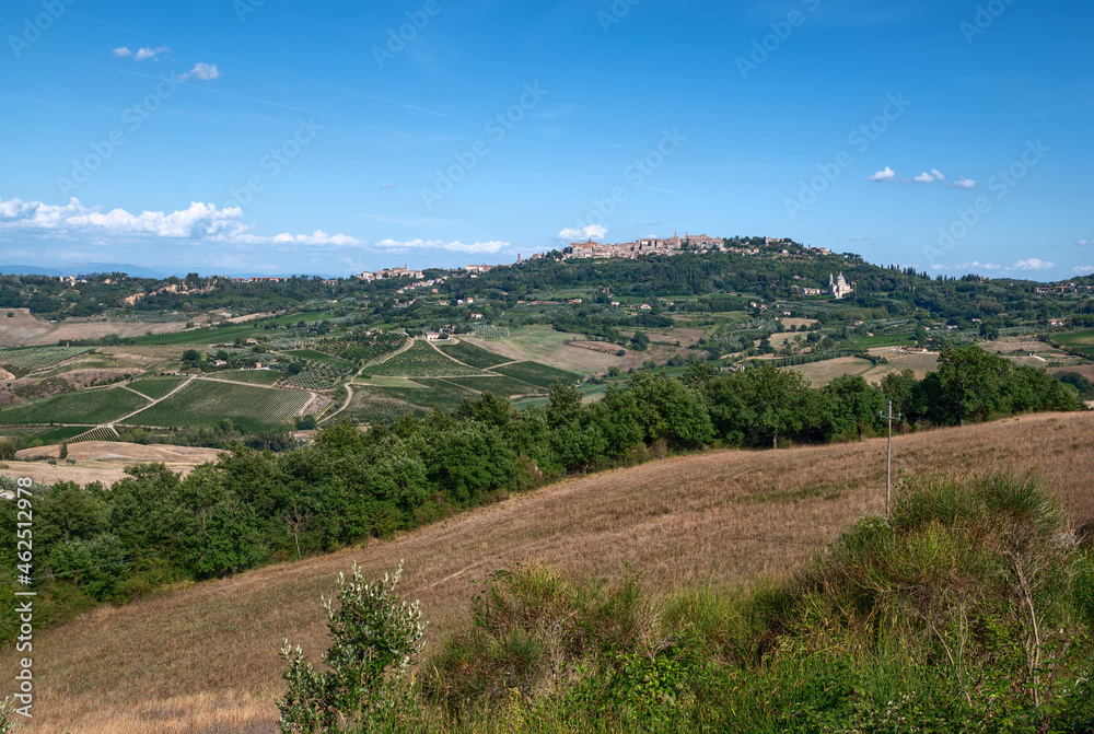 Montepulciano, Tuscany, Italy. August 2020. Amazing landscape of the Tuscan countryside with the historic village of Montepulciano on the top of the hill. Beautiful summer day.