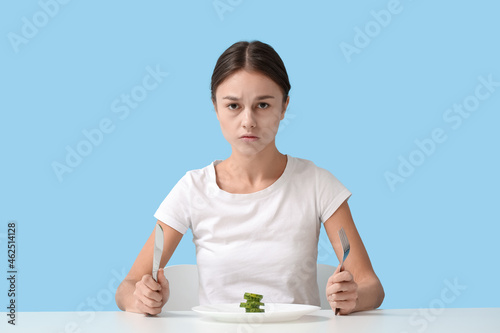 Young woman at table agains...