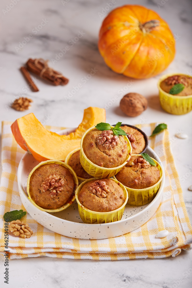 Muffins with pumpkin, walnuts and cinnamon. Delicious homemade dessert. Halloween treats. Vegetarian dish.