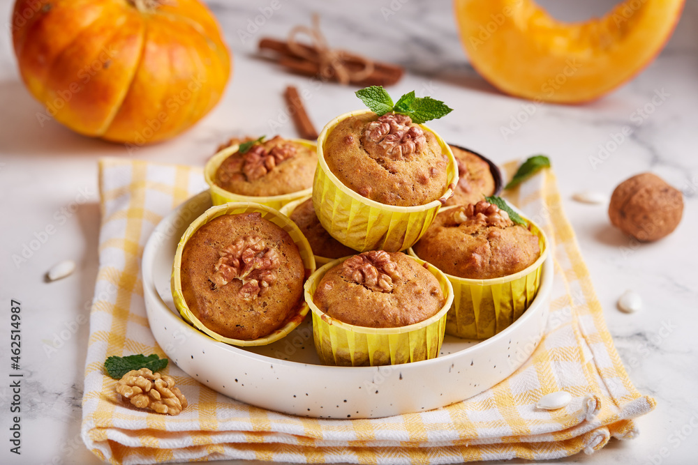 Muffins with pumpkin, walnuts and cinnamon. Delicious homemade dessert. Halloween treats. Vegetarian dish.