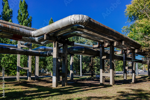 Steel pipelines outgoing from the plant at sunny day