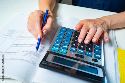 Close up of beautiful woman hands using calculator keyboard. Concept of accountant work. Financial director at work. Woman checks the payments. Calculation of income and expenses. Finance and budget