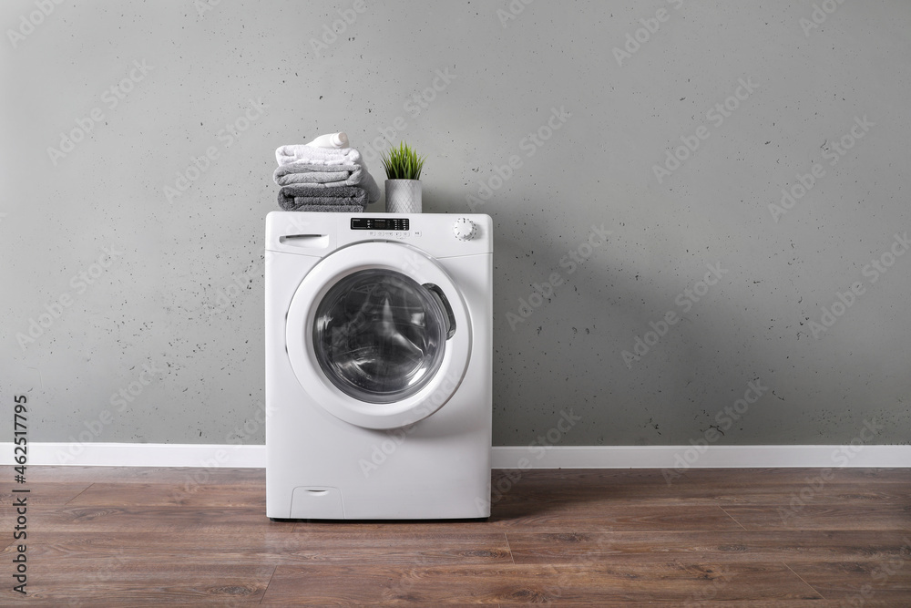 Clothes washing machine in grey laundry room - obrazy, fototapety, plakaty 