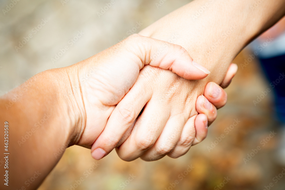Diagonal composition. Two hands shaking outdoors. Team work and agreement setting. Women solidarity and support. Caucasian palm. Strength and collaboration. Greeting friends outdoors. Make business