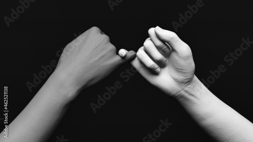 3D illustration of gray and white statue hands teasing each other's little fingers in a dark space. Promising gesture. photo