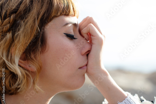 A young blonde beautiful woman thinking with eyes closed