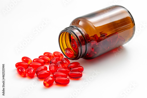 Addictive pain relief drug, oral administration therapeutic medicine and healing science concept with many spilling red prescription medication isolated on white background