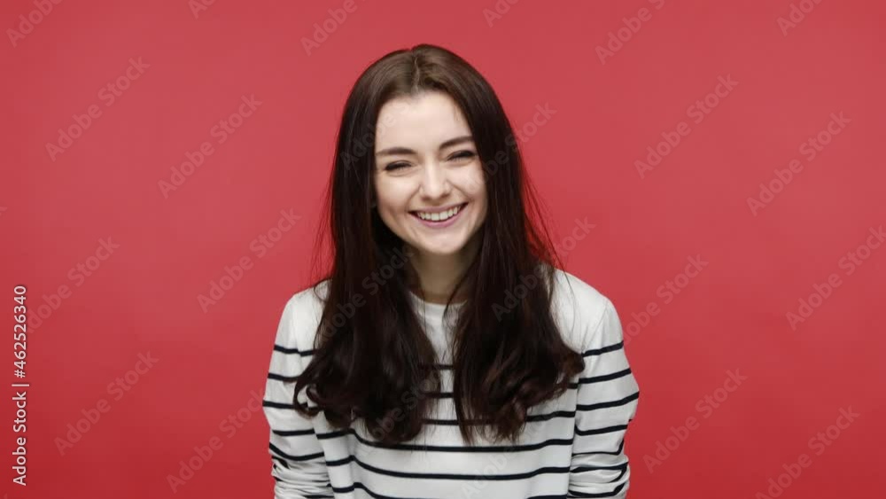 Portrait of woman laughing out loud, chuckling giggling at amusing anecdote, sincere emotion, wearing casual style long sleeve shirt. Indoor studio shot isolated on red background. Portrait of woman laughing out loud, chuckling giggling at amusing anecdote, sincere emotion, wearing casual style long sleeve shirt. Indoor studio shot isolated on red background.