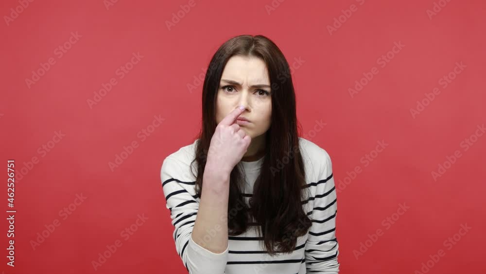 Portrait of brunette woman pointing at her nose, saying to trickster you are liar, body language, wearing casual style long sleeve shirt. Indoor studio shot isolated on red background. Portrait of brunette woman pointing at her nose, saying to trickster you are liar, body language, wearing casual style long sleeve shirt. Indoor studio shot isolated on red background.