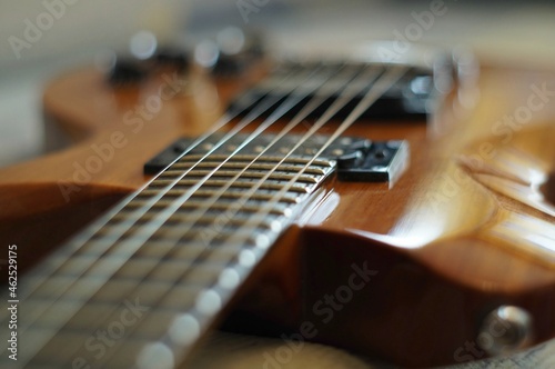 Streams and Bridges. Closeup shot of a wooden laquered body of electric guitar with strings, pickups and bridge