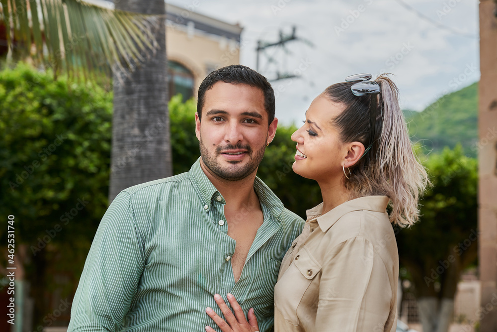 Young Latino male and female couple looking at each other in love between 25 and 35 years old