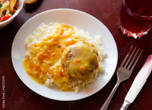Russian cuisine, boiled meatball tefteli with rice and sauce, served with glass of compote photo