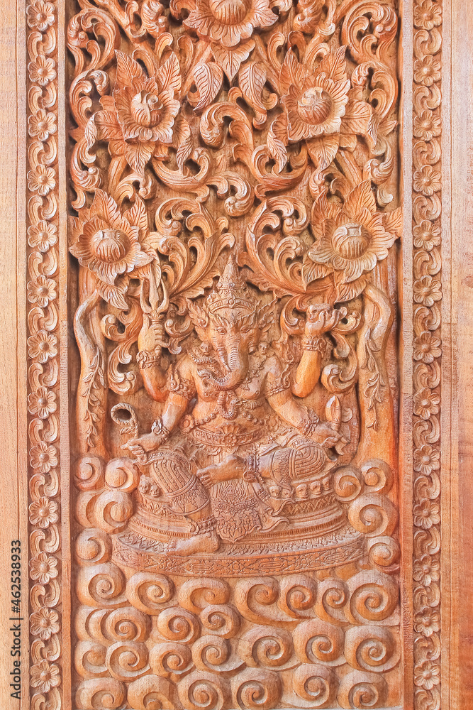Carved pattern on teak wood Ganesha, wall of temple in Thailand