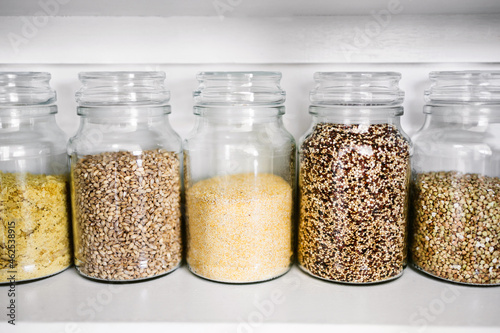clear pantry jars with grains and healthy ingredients including quinoa buckwheat polenta and barley, simple ingredients concept