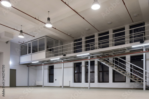 Interior of a large industrial space with mezzanine at night photo