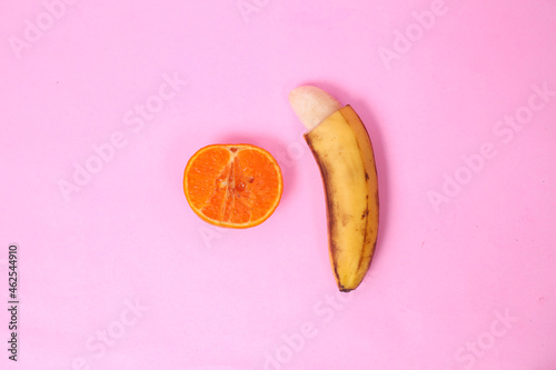Quadro su tela sex education with oranges and bananas isolated on pink background