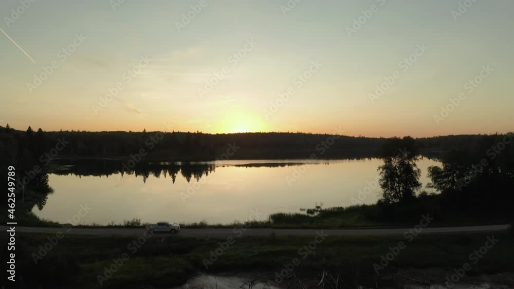 Truck drives along lake, edge of Boreal Forest, Saskatchewan at sunset. Flyover. Truck drives along lake, edge of Boreal Forest, Saskatchewan at sunset. Flyover.