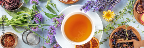 Tea panorama with herbs, flowers and fruit, an overhead flat lay shot. Healthy hot drink panoramic banner with lavender