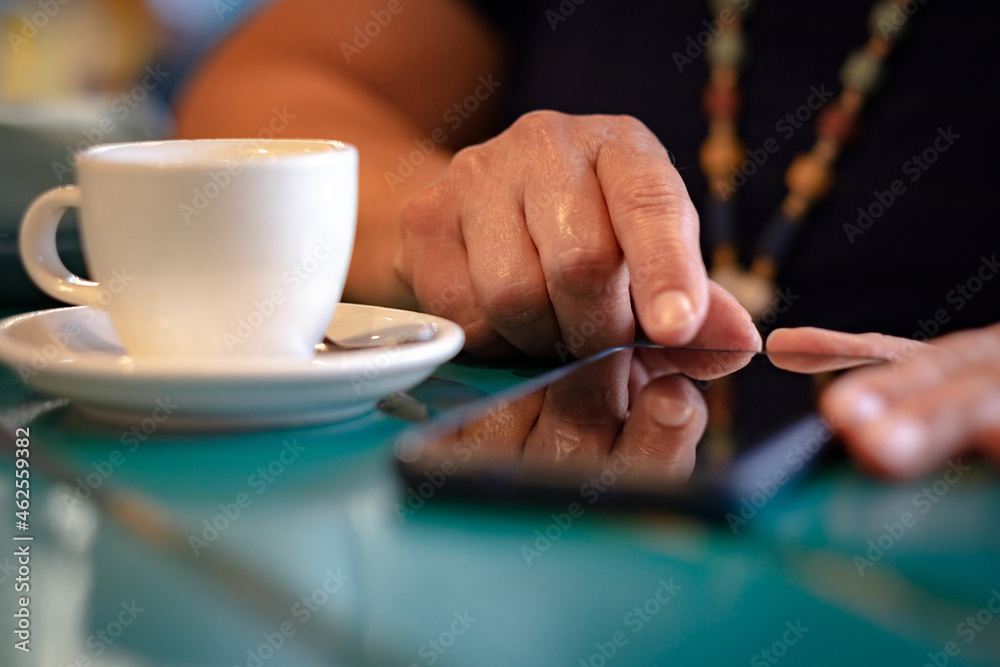 Close up on woman with white coffee cup on table, messaging with mobile phone. Sitting and enjoying tech and social - obrazy, fototapety, plakaty 