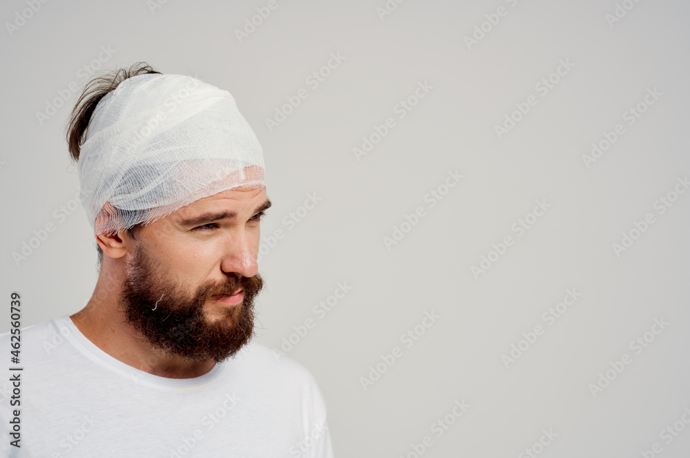 bearded man bandaged head and hand blood treatment